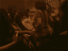 a group of people are dancing in a dark room in a club .