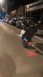 a person riding a motorcycle down a street with a sign that says ' abercrombie & fitch '
