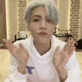 a man wearing a white sweatshirt with a purple bird on it