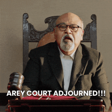 a man in a suit and glasses sitting in a chair with the words arey court adjourned below him