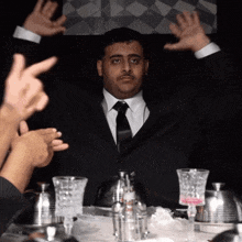 a man in a suit and tie is sitting at a table