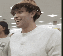 a man wearing a hat and a white shirt with the word all star on it smiles