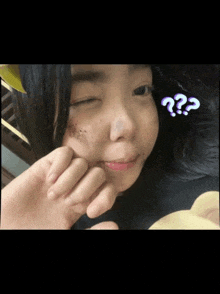 a close up of a girl 's face with a purple question mark on it