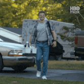 a man is carrying a bucket of cleaning supplies while walking down a street with hbo max written on the bottom
