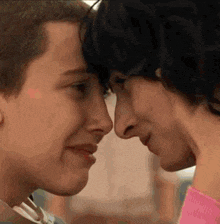 a man and a woman are looking at each other 's faces and touching their noses .