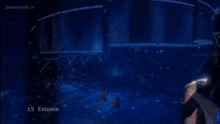 a woman singing into a microphone with the number 15 on the bottom right