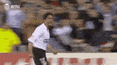a man in a white shirt with the number 14 on it is running on a field .