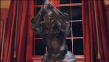 a statue of a knight in armor is standing in front of a window .