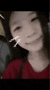 a close up of a woman 's face with a red shirt on