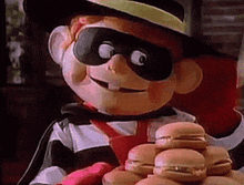 a mascot is holding a bunch of hamburgers in his hands