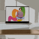 a laptop screen shows a woman sitting on the floor using a laptop
