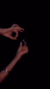 a close up of a person 's hands with sparkles coming out of them against a black background