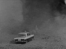 a black and white photo of a fire burning on a hillside