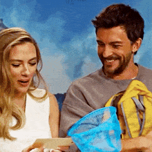 a man and a woman are smiling and looking at a piece of paper