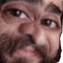 a close up of a man 's face with a beard making a face .