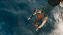 a woman is upside down in the air looking at something