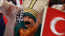 a man in a costume with a mustache is holding a flag that has the letter c on it