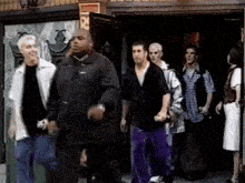 a group of people are walking in front of a building with a sign that says ' rc ' on it