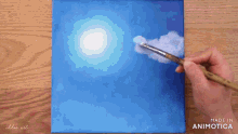 a person is painting a blue sky with a brush and the words made in animotica on the bottom