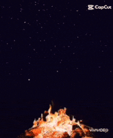 a campfire is exploding in the night sky with a caption that says capcut