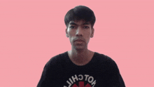 a man wearing a red hot chili peppers shirt shows his hands