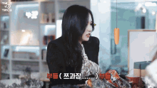 a woman is sitting at a table with a sign that says twice on it