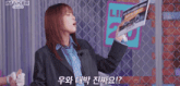 a woman in a suit is holding up a sign that says " maker "