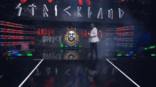 a man in a white suit is dancing in front of a wall that says whose house