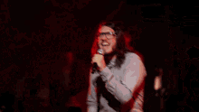 two men singing into microphones on a stage