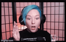 a woman with blue hair is wearing headphones and a microphone .