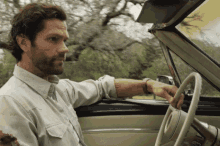 a man driving a car with a tattoo on his arm that says ii