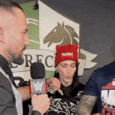 a man is talking into a microphone with a w on it