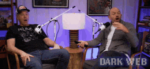 two men are sitting in front of microphones and the words dark web are visible