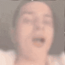 a close up of a woman 's face with her mouth open and her tongue sticking out .