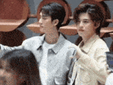 a couple of young men standing next to each other