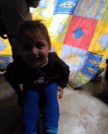 a child is sitting under a colorful blanket that says mcdonald 's