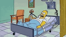 homer simpson is laying in a hospital bed with an oxygen mask .