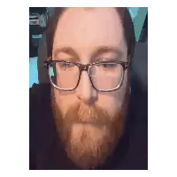 a man with a beard and glasses is making a face