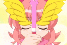 a girl with pink hair and yellow wings holds a pink object in her hand .
