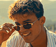 a young man wearing sunglasses is smiling for the camera