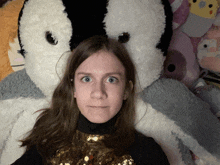 a girl laying on a bed with a stuffed animal behind her
