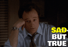 a man in a blue shirt and tie is sitting at a desk with the words sad but true above him