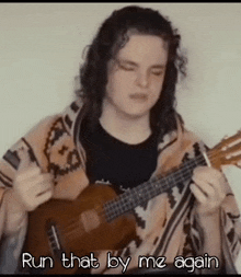 a man playing a guitar with the words run that by me again