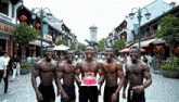 a group of muscular men holding a birthday cake