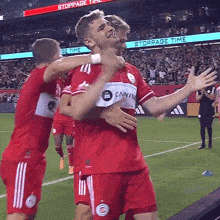 a group of soccer players are hugging each other in front of a sign that says " stoppage time "
