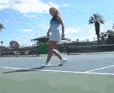 a woman is walking on a tennis court with a racket in her hand