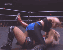 a woman is wrestling another woman in a wrestling ring on a tv show .