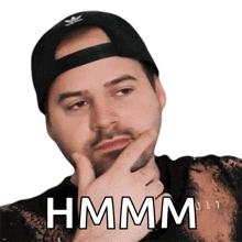 a man wearing a black hat has his hand on his chin and says hmm