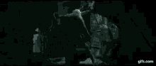 a person is standing in a dark room with a light coming out of the ceiling .