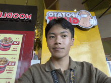 a man taking a selfie in front of a sign that says potato